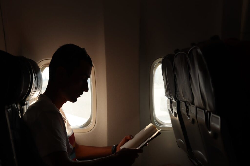 a man reading a book during flight